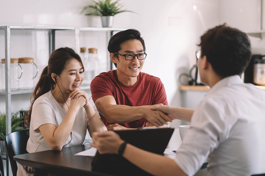 Couple meeting with a professional, smiling.