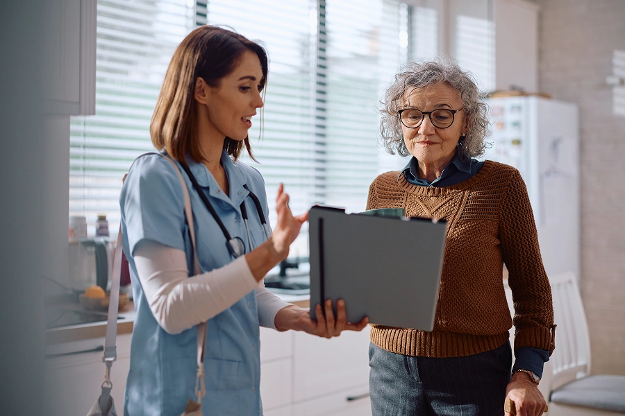 Doctor discussing chart with elderly patient.