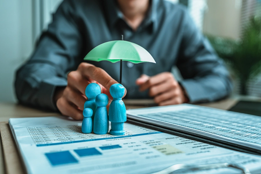 Wooden figures under umbrella on documents.