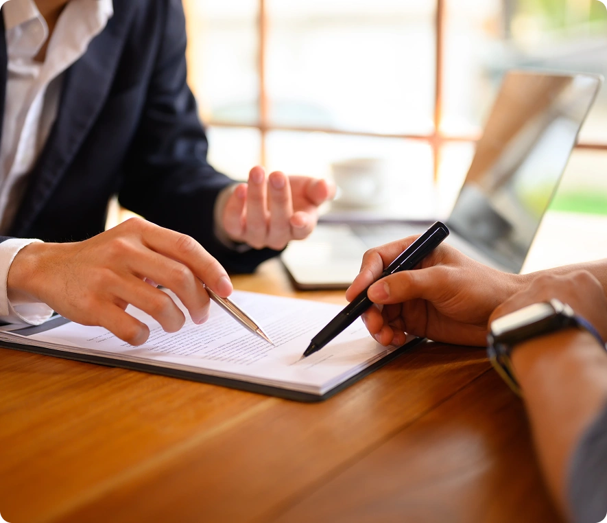 Two people discussing document at desk.