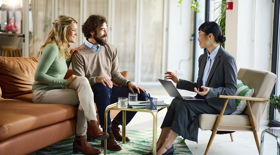 Couple meeting with business adviser, discussing plans.